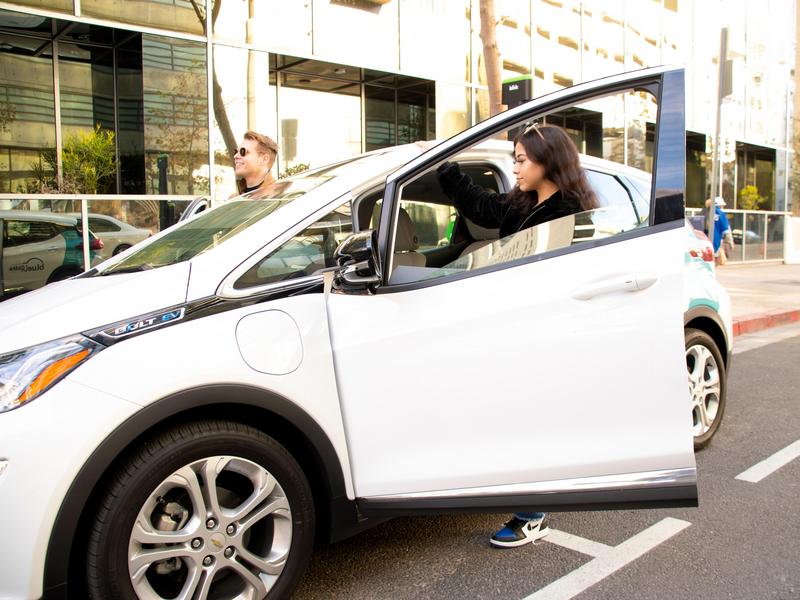 Young couple entering a Chevy Bolt in a Blink Mobility Station located in 820 Hope 8th Street, Los Angeles